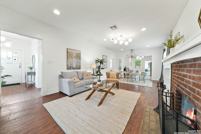 living room featuring dark wood-style floors, a brick fireplace, visible vents, and recessed lighting