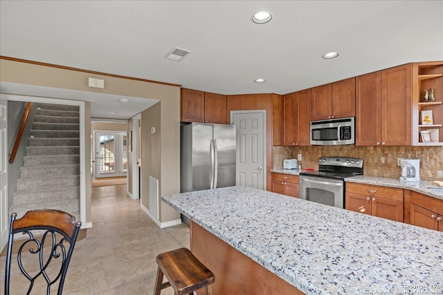 kitchen with brown cabinets, light stone countertops, stainless steel appliances, open shelves, and backsplash