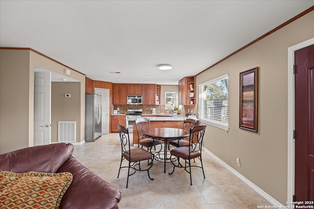 dining room featuring visible vents, crown molding, and baseboards