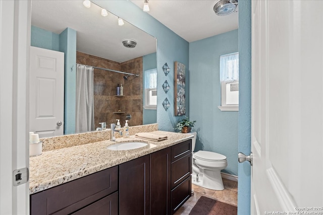 full bathroom featuring a wealth of natural light, a tile shower, vanity, and toilet