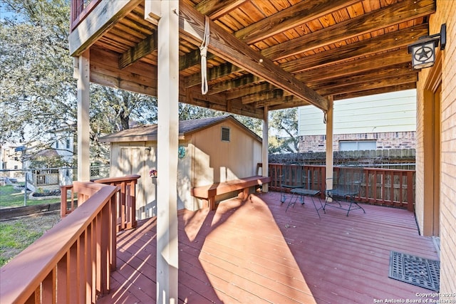 wooden terrace featuring fence and an outbuilding