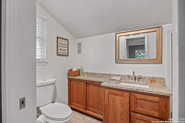 bathroom with lofted ceiling, toilet, and vanity