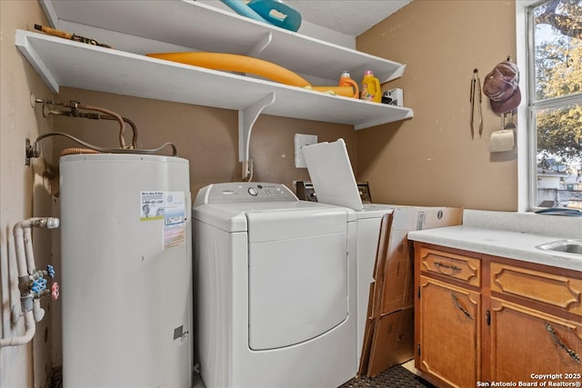 laundry room with gas water heater, cabinet space, independent washer and dryer, and a sink