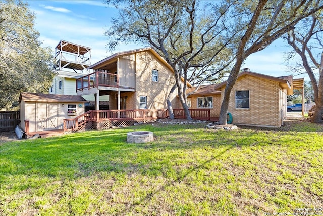 rear view of house with an outdoor fire pit, an outbuilding, a storage unit, a yard, and brick siding