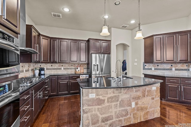 kitchen with visible vents, appliances with stainless steel finishes, arched walkways, and a sink