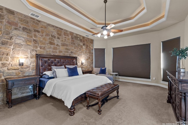 bedroom featuring carpet floors, crown molding, a raised ceiling, visible vents, and ceiling fan