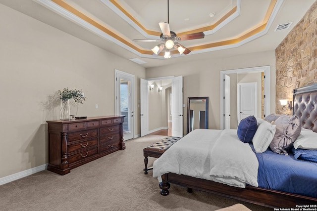 bedroom featuring a raised ceiling, light colored carpet, visible vents, ornamental molding, and baseboards