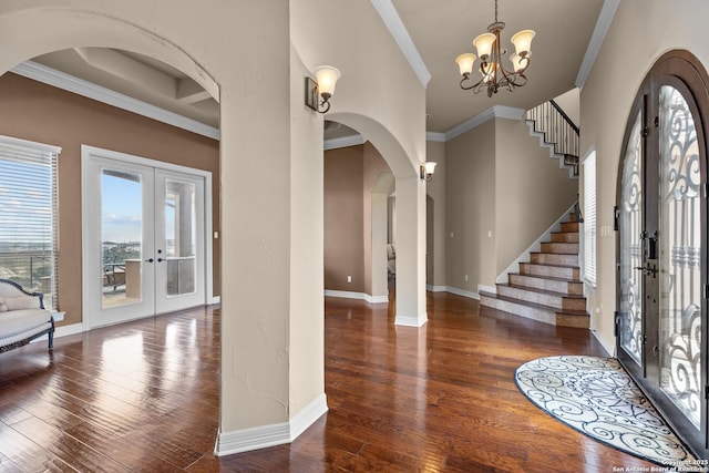 entrance foyer featuring baseboards, hardwood / wood-style flooring, stairs, crown molding, and french doors