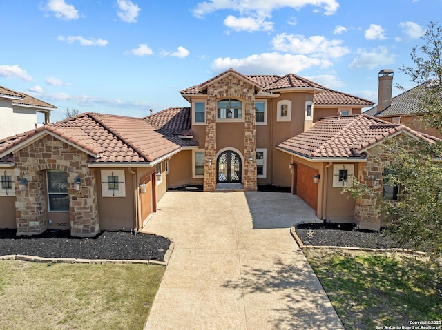 mediterranean / spanish home featuring french doors, a tile roof, driveway, and stucco siding