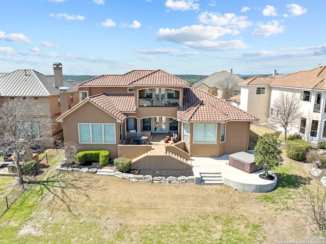 back of property with a tiled roof, a patio area, and stucco siding