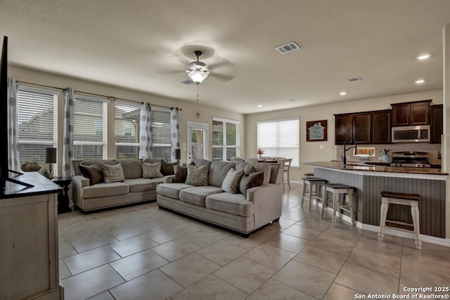 living room with light tile patterned floors, recessed lighting, visible vents, ceiling fan, and baseboards