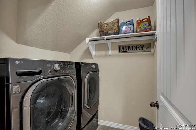 washroom featuring laundry area, a textured ceiling, baseboards, and separate washer and dryer