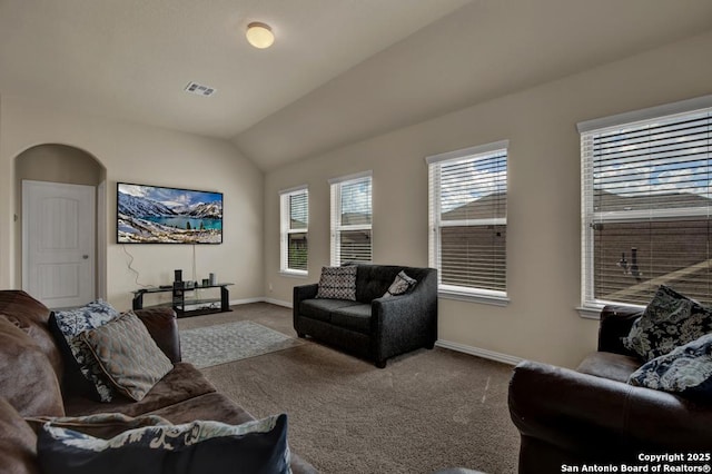 living area with arched walkways, visible vents, carpet flooring, vaulted ceiling, and baseboards