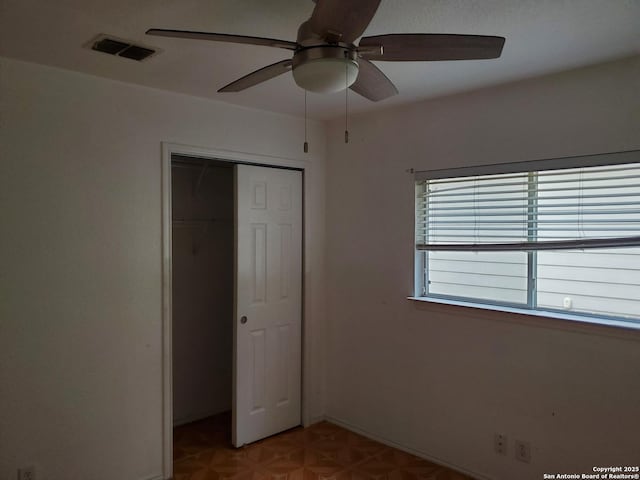 unfurnished bedroom featuring light floors, a closet, visible vents, ceiling fan, and baseboards