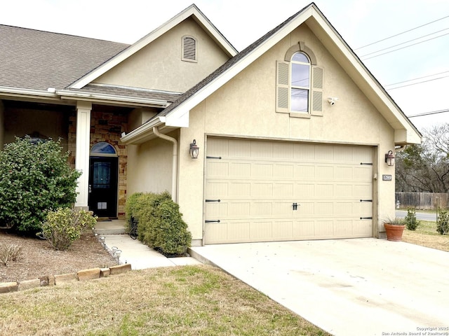 view of front of home featuring a garage, concrete driveway, a shingled roof, and stucco siding