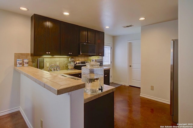 kitchen with visible vents, decorative backsplash, appliances with stainless steel finishes, dark brown cabinetry, and baseboards