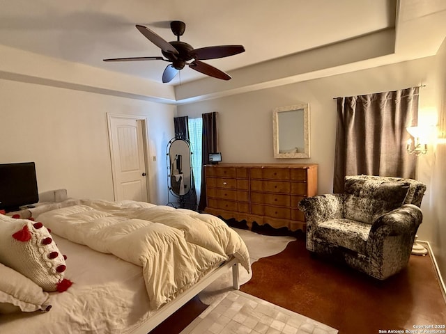 bedroom with a tray ceiling and a ceiling fan