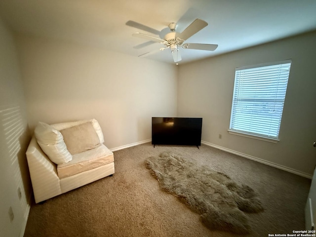 living area with carpet, a ceiling fan, and baseboards