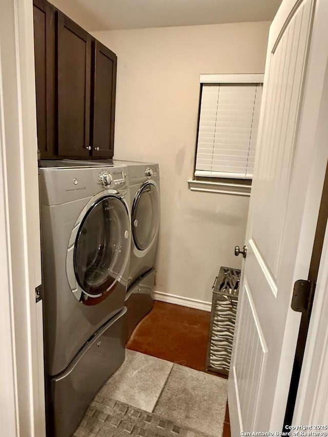 laundry area with cabinet space, washing machine and dryer, and baseboards