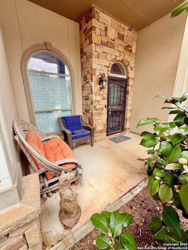 entrance to property featuring stone siding and stucco siding