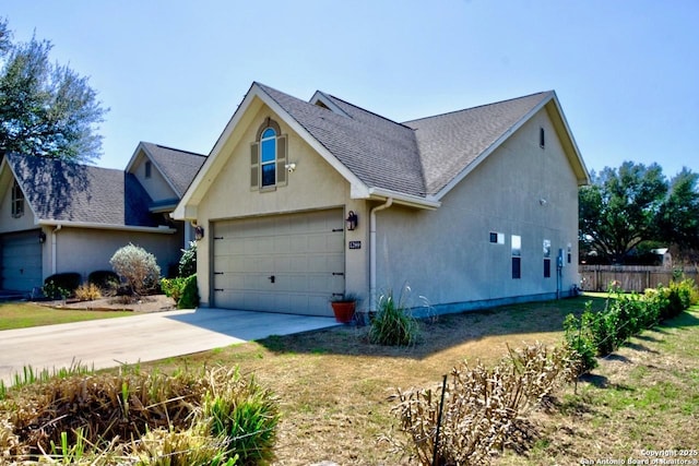 traditional home with roof with shingles, a front yard, fence, a garage, and driveway