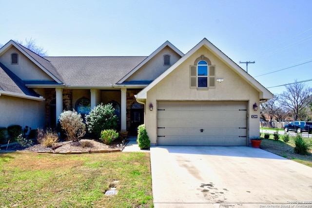 traditional-style home with a garage, driveway, roof with shingles, and stucco siding