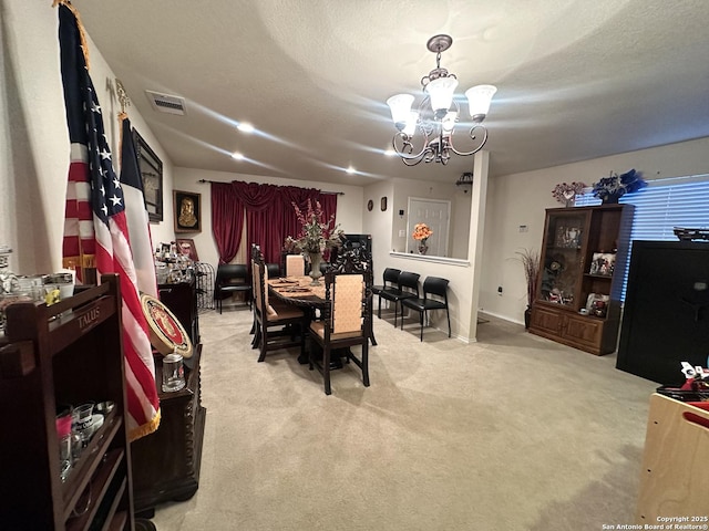 dining area with light carpet, an inviting chandelier, visible vents, and a textured ceiling