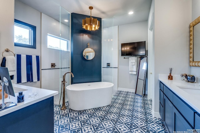 full bathroom with baseboards, a soaking tub, a sink, tile patterned flooring, and two vanities