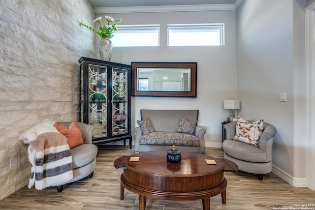 sitting room with crown molding, baseboards, and wood finished floors