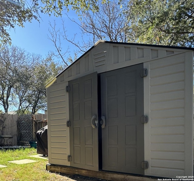 view of shed featuring fence