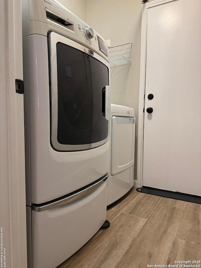 laundry room featuring laundry area, independent washer and dryer, and wood finished floors