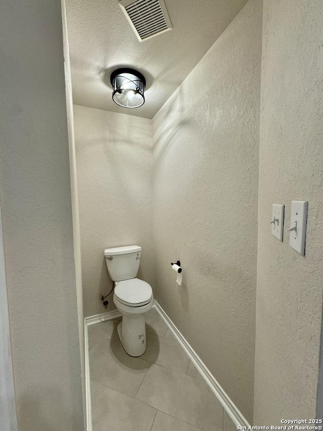 bathroom with visible vents and a textured wall