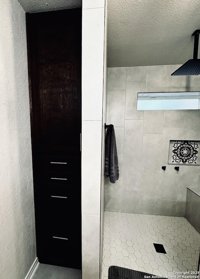 full bathroom featuring a textured ceiling and a shower stall