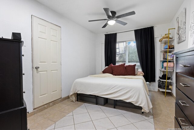 bedroom with light tile patterned floors, a ceiling fan, and baseboards