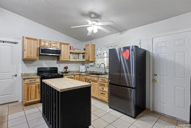 kitchen with stainless steel appliances, light brown cabinets, a sink, and ceiling fan