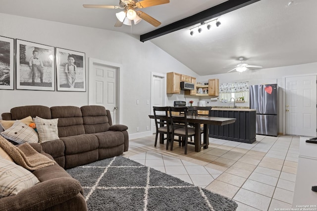 living area with vaulted ceiling with beams, light tile patterned floors, baseboards, and a ceiling fan