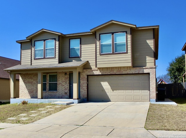 view of front of home featuring an attached garage, driveway, brick siding, and a porch