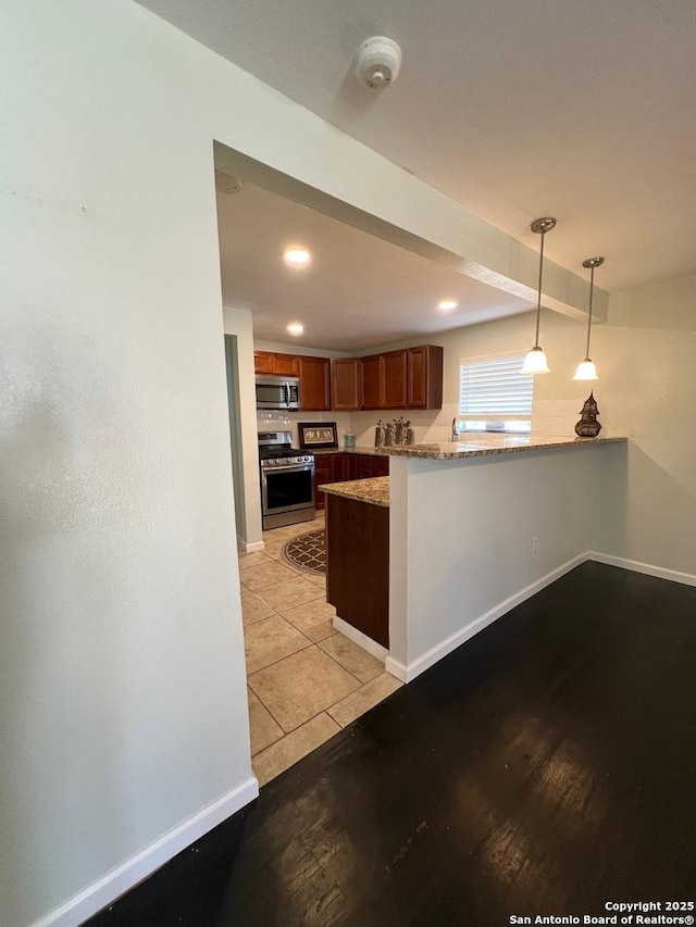 kitchen with recessed lighting, baseboards, hanging light fixtures, appliances with stainless steel finishes, and brown cabinetry