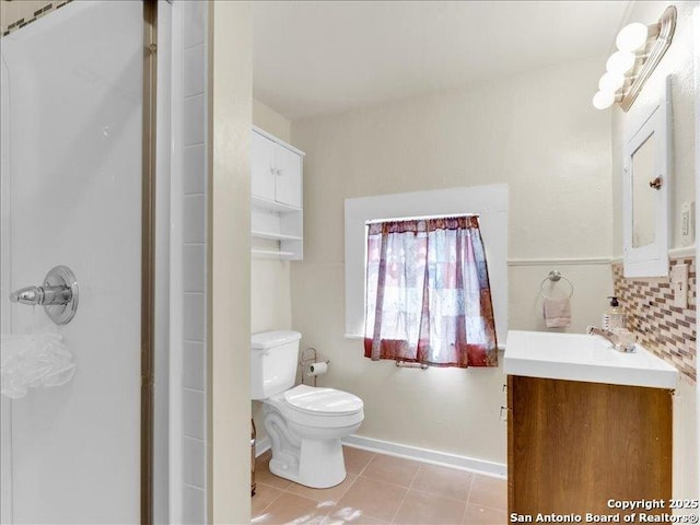 bathroom featuring baseboards, a shower, toilet, tile patterned flooring, and vanity