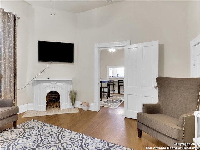 living room with a high ceiling, baseboards, and wood finished floors