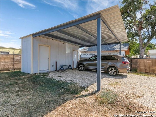 view of car parking featuring a carport and fence