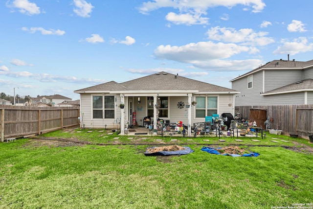 rear view of property with a patio, a lawn, and a fenced backyard