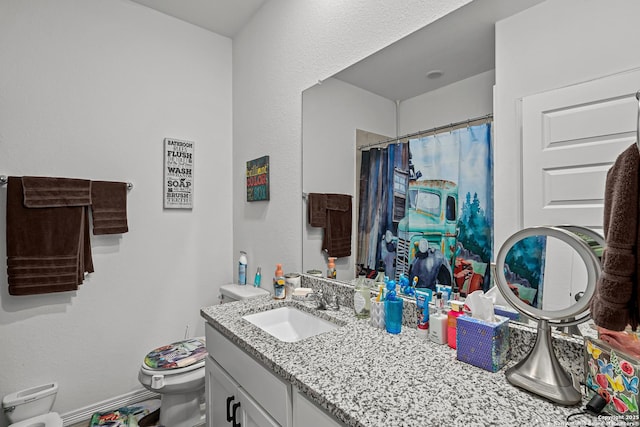 bathroom featuring curtained shower, vanity, and toilet