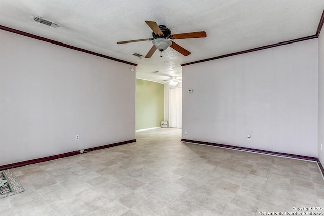 spare room featuring visible vents, ornamental molding, ceiling fan, and baseboards