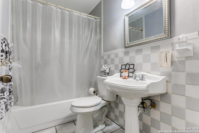 bathroom with toilet, shower / bath combo, tile walls, and tile patterned floors