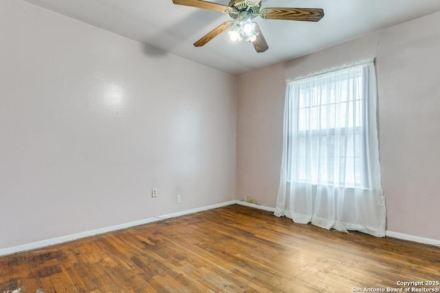 unfurnished room featuring ceiling fan, baseboards, and wood finished floors