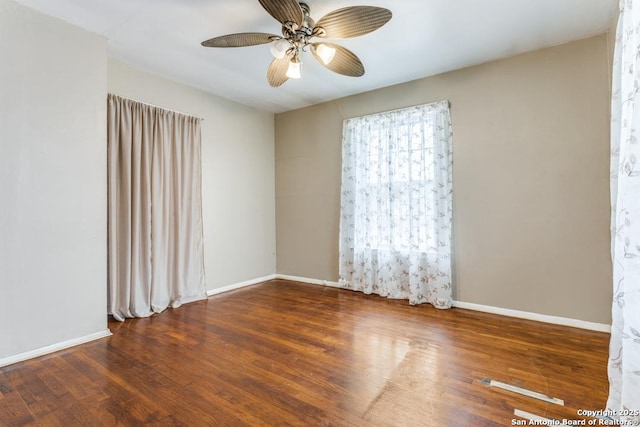 empty room featuring ceiling fan, wood finished floors, and baseboards