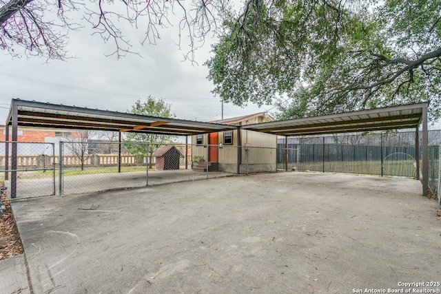 view of vehicle parking featuring a gate, fence, a carport, and concrete driveway