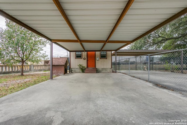 view of patio featuring a carport, entry steps, fence, and an outdoor structure