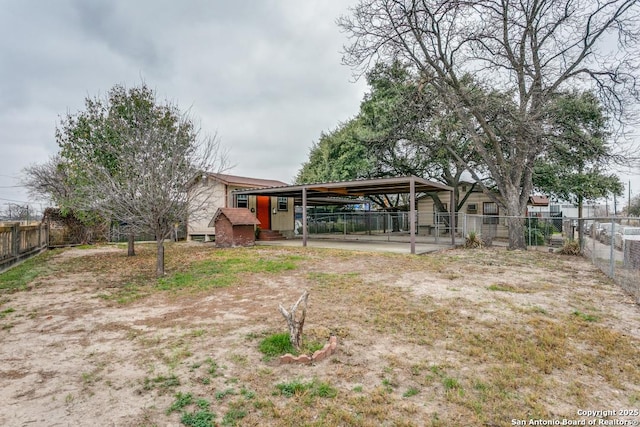 view of yard featuring a carport and fence